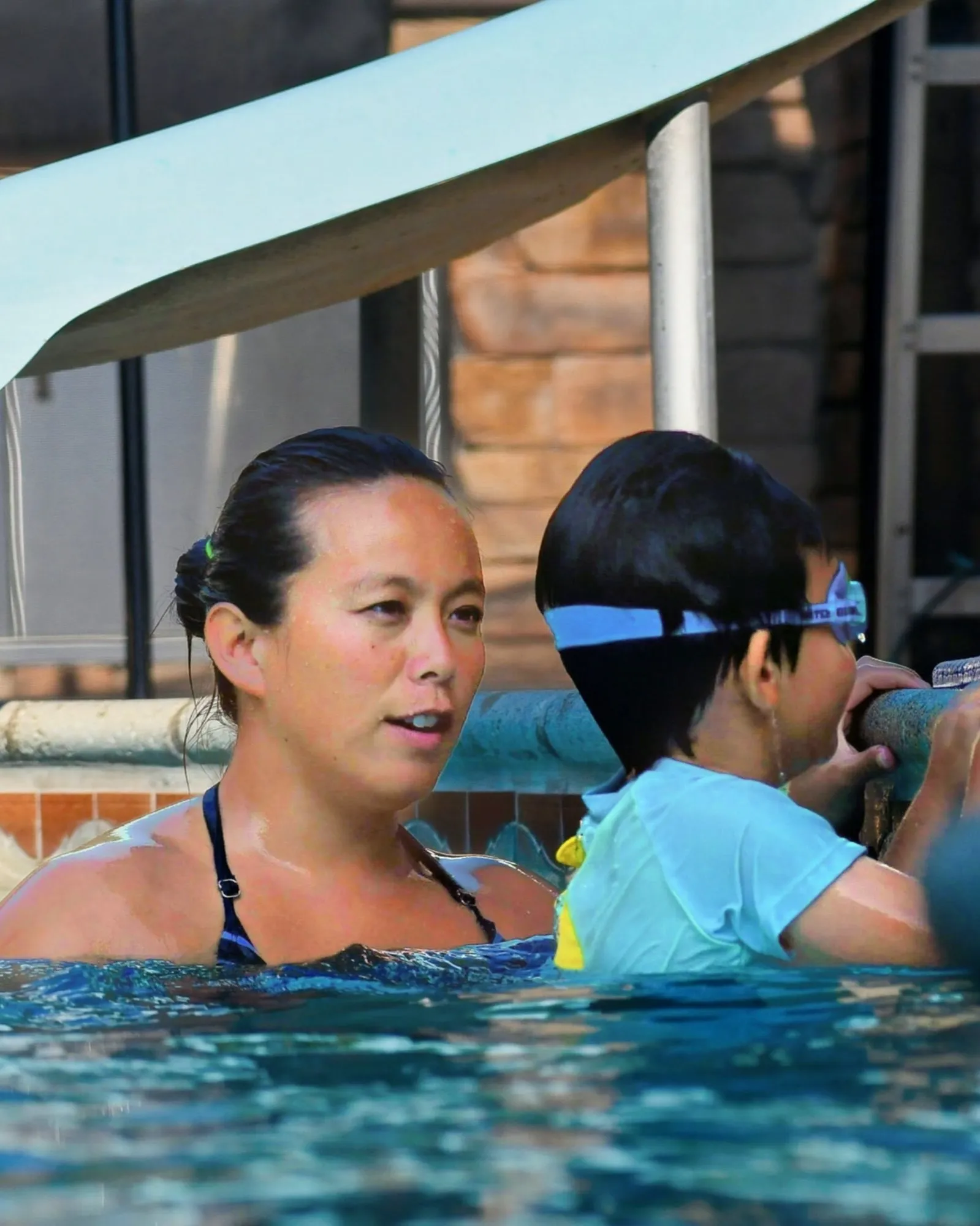 Wendy Inoue guiding a young swimmer during a private lesson
